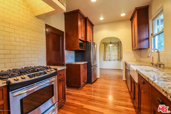 a kitchen with stainless steel appliances granite countertop a stove a sink and a refrigerator