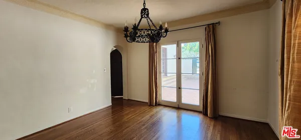a view of a room with wooden floor and door