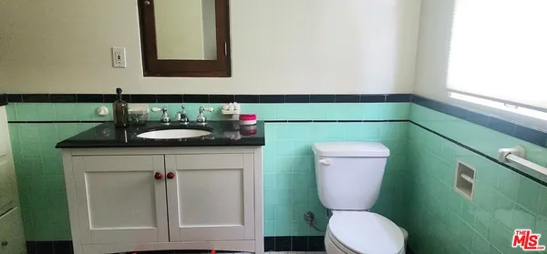 a bathroom with a toilet sink and mirror