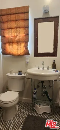 a bathroom with a sink a toilet and mirror