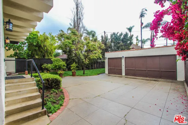 a view of a house with a yard and potted plants