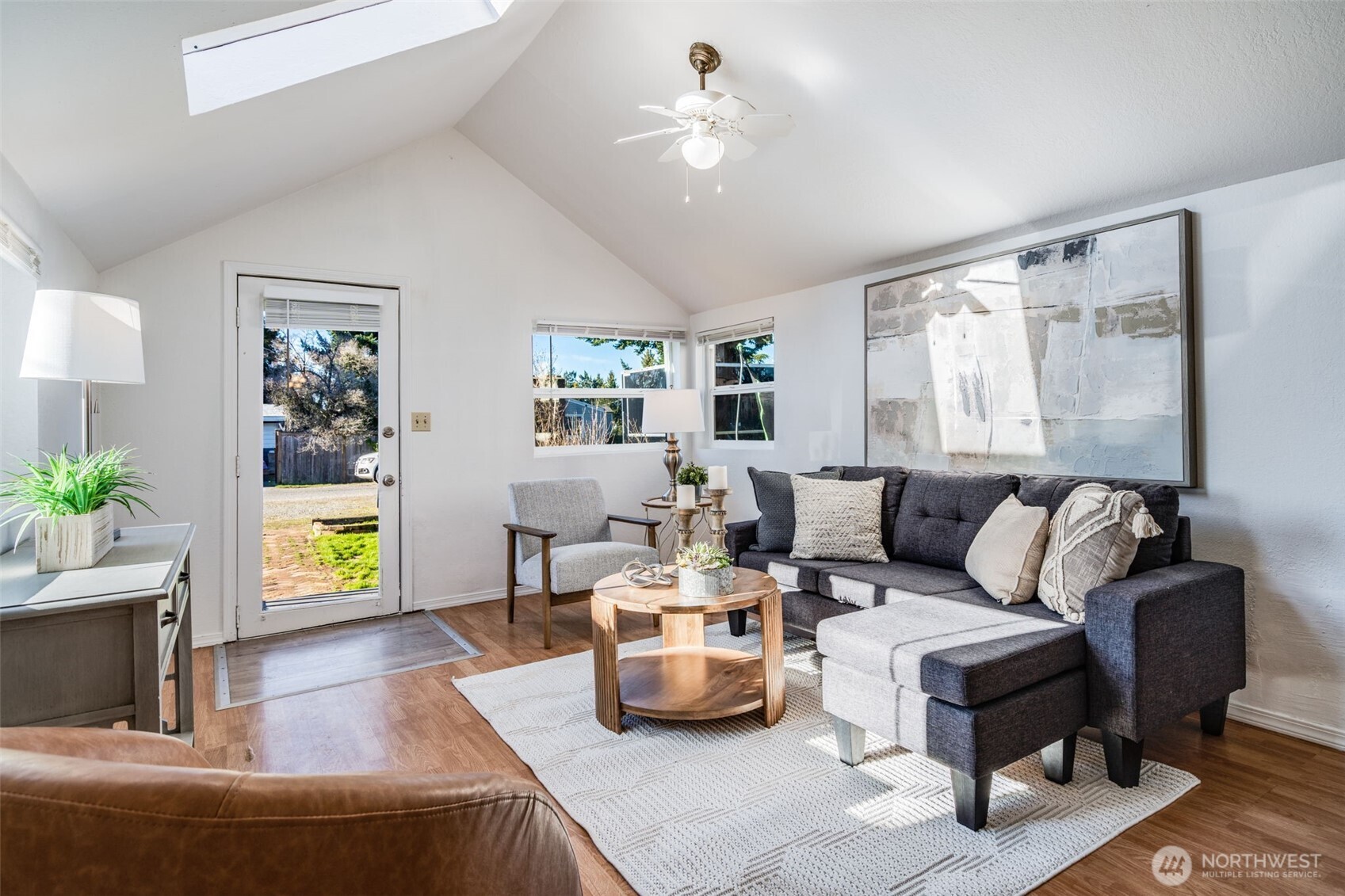 a living room with furniture and a painting on the wall