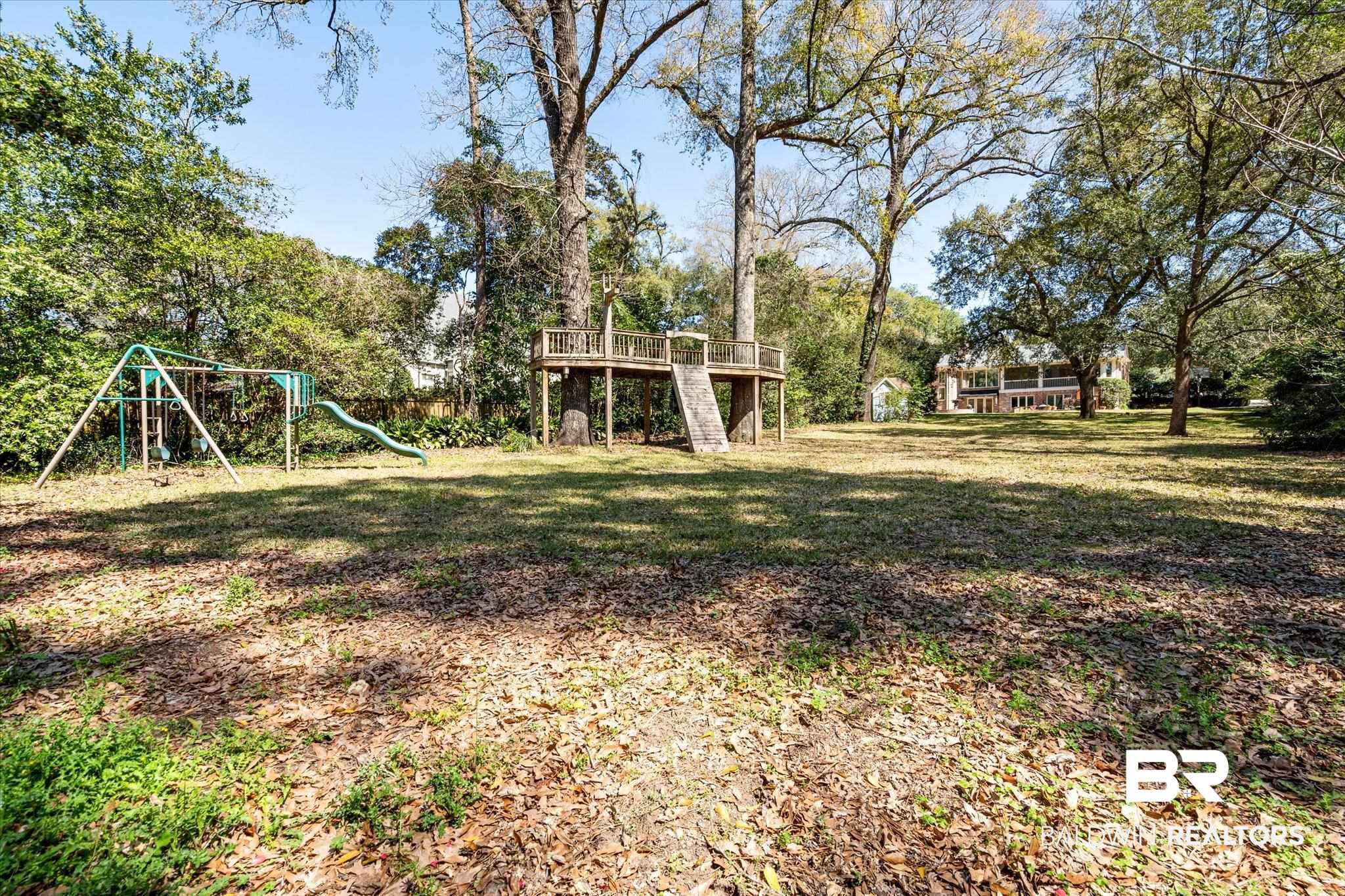 4 Kingsway Mobile, AL 36608 - Photo 35 of 44 View of yard with stairs, a deck, and playground community