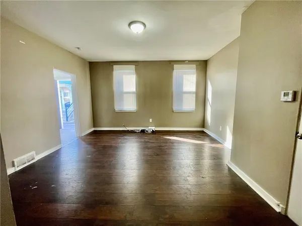 wooden floor in an empty room with a window