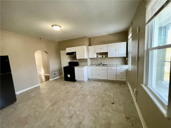 a large white kitchen with cabinets and a refrigerator