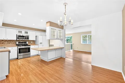 a large kitchen with cabinets wooden floor and stainless steel appliances