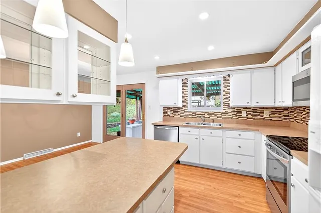 a kitchen with stainless steel appliances granite countertop a stove and a sink