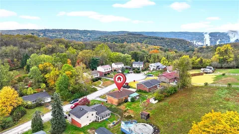 a front view of house with yard and trees in the background