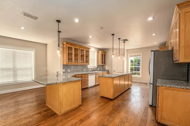 an empty room with windows and ceiling fan