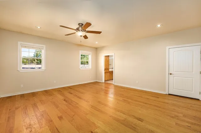 an empty room with a window and a fan