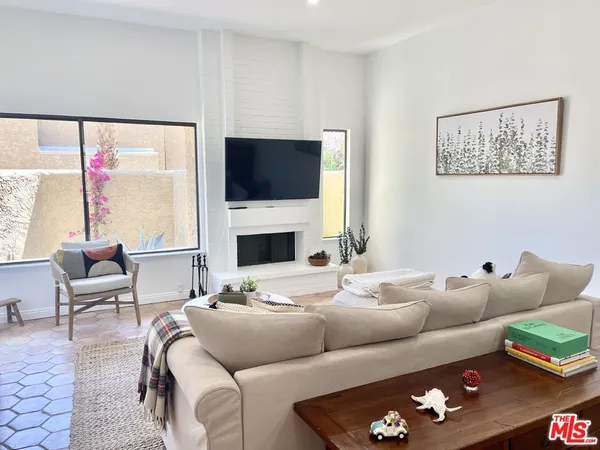 a living room with furniture a flat screen tv and a fireplace