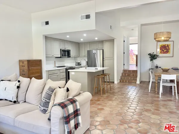 a living room with furniture and kitchen view