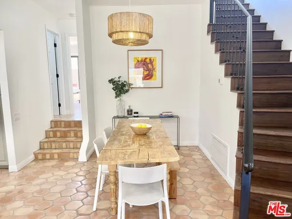 a view of a hallway with dining area and chandelier