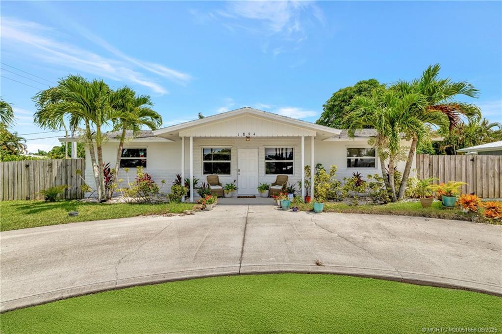 1894 Southeast Lafayette Street Stuart, FL 34997 - Photo 1 of 32 a front view of a house with a yard and garage
