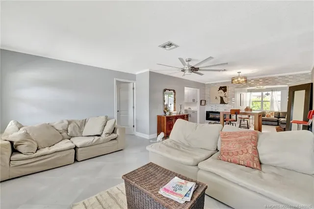a living room with furniture white walls and a lamp