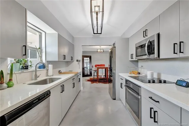 a kitchen with stainless steel appliances granite countertop a sink and dishwasher a stove top oven with wooden floor