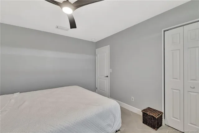 a bedroom with a bed and a ceiling fan