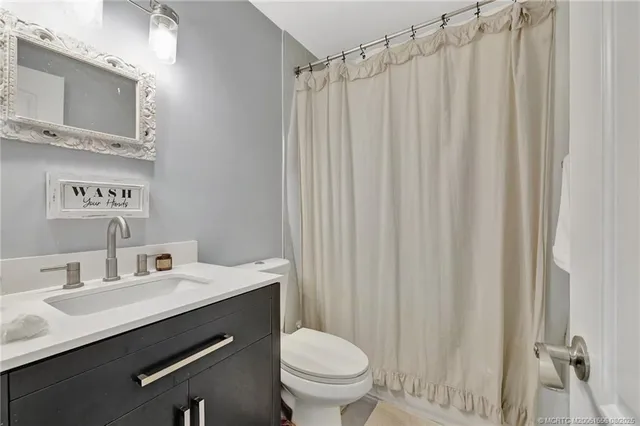 a bathroom with a sink a toilet and shower curtain