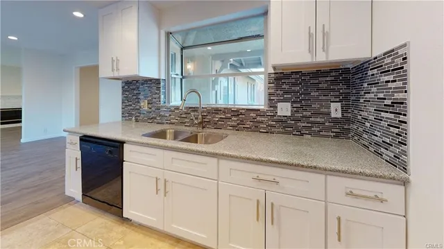 a kitchen with stainless steel appliances granite countertop a stove top oven a sink dishwasher a microwave oven and a granite counter top