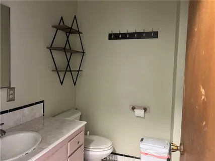 a bathroom with a granite countertop sink toilet and mirror