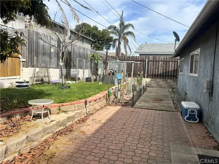 a view of a patio with table and chairs with wooden floor and fence