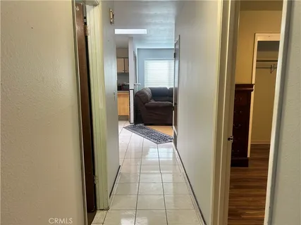a view of a hallway with a glass door and furniture