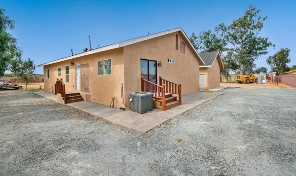 a view of a house with backyard and a tree