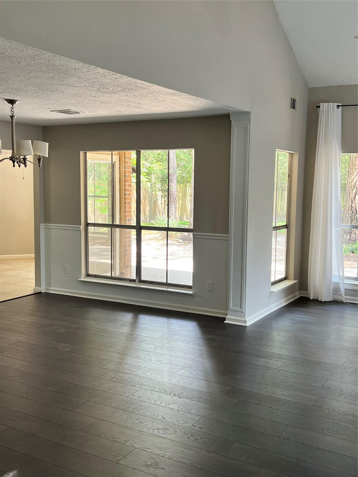 5 Spurwood Court The Woodlands, TX 77381 - Photo 3 of 16 an empty room with wooden floor and windows with curtains