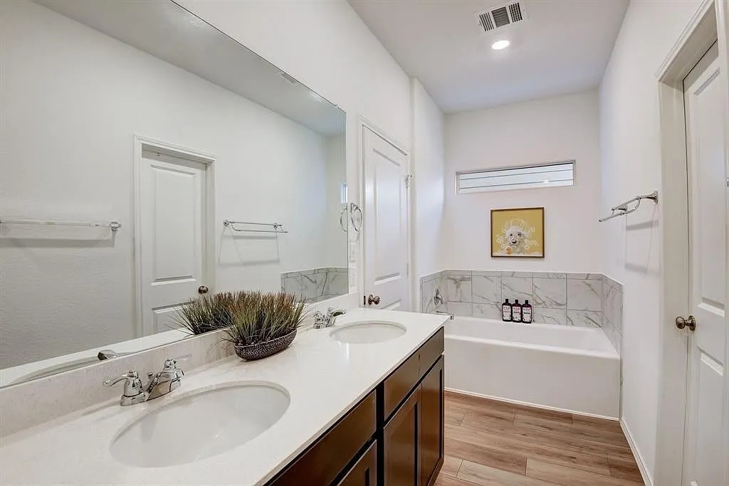 171 Santa Julia Kyle, TX 78640 - Photo 8 of 18 Bathroom featuring a bath, light wood-style flooring, and double vanity