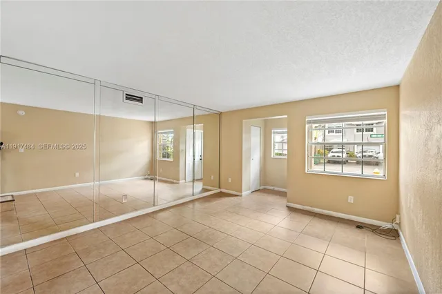 a view of an empty room with window and a bathroom