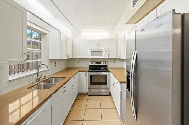a kitchen with granite countertop a refrigerator and a sink