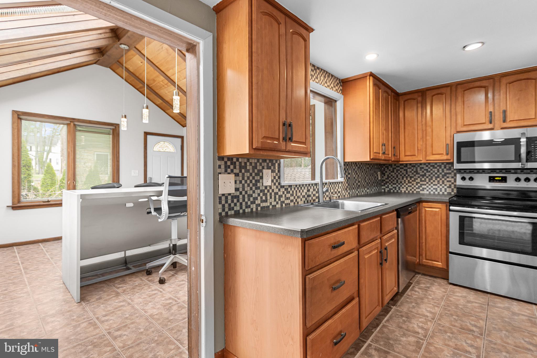 118 Powell Road Springfield, PA 19064 - Photo 23 of 33 a kitchen with stainless steel appliances granite countertop a stove a sink and a refrigerator