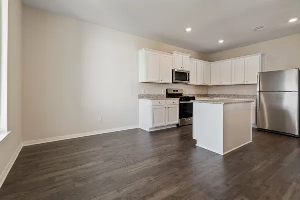 a kitchen with cabinets and wooden floor
