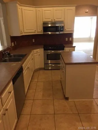 a kitchen with a sink a stove and cabinets