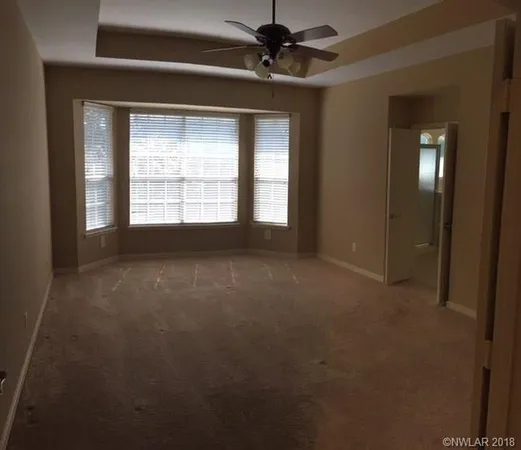 a view of a livingroom with a ceiling fan and window