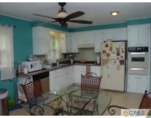 54 Poplar Road Piscataway, NJ 08854 - Photo 3 of 6 a kitchen with stainless steel appliances kitchen island granite countertop a refrigerator a stove a sink and white cabinets with wooden floor