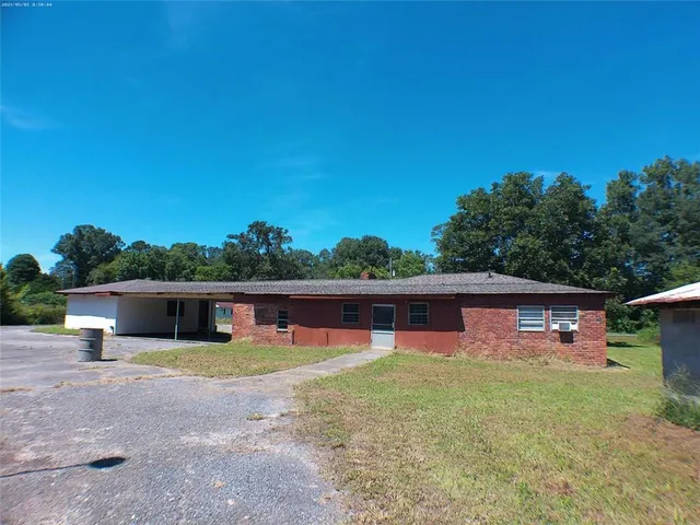 a view of a house with pool and a yard
