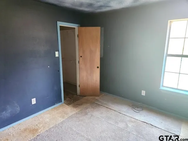an empty room with windows and closet