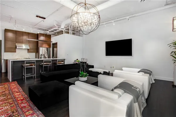 a living room with furniture a flat screen tv and kitchen view