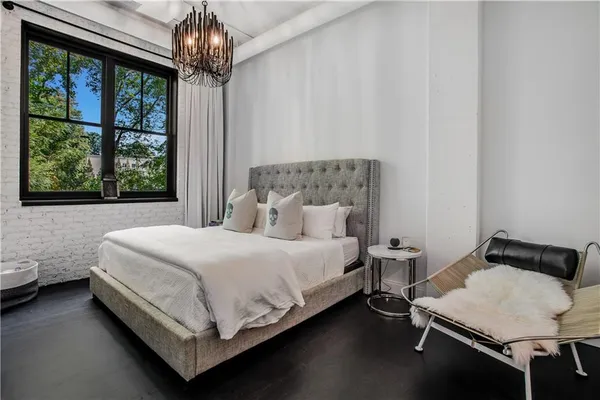 a bed sitting in a bedroom next to a window