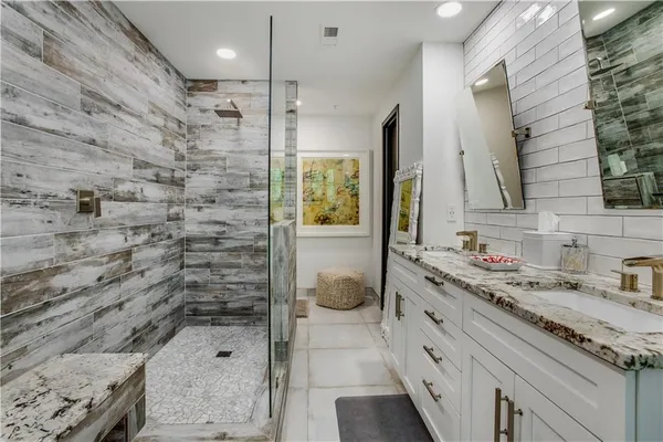 a bathroom with a granite countertop sink a vanity and a shower