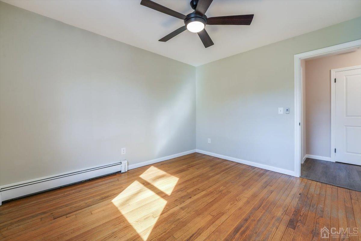 364 New Market Road Dunellen, NJ 08812 - Photo 15 of 36 an empty room with wooden floor and windows