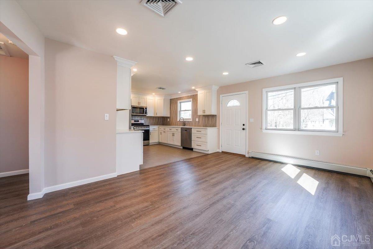 364 New Market Road Dunellen, NJ 08812 - Photo 27 of 36 a view of an empty room and kitchen with wooden floor