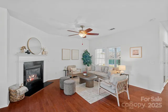 a living room with furniture a fireplace and wooden floor