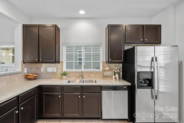 a kitchen with stainless steel appliances granite countertop a refrigerator and a sink