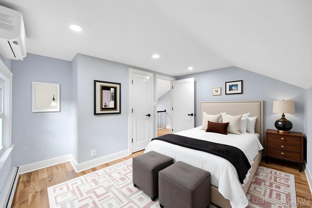 15 Superior Road Bellerose Village, NY 11001 - Photo 11 of 29 Bedroom with a baseboard radiator, a wall mounted AC, light wood-style flooring, vaulted ceiling, and recessed lighting