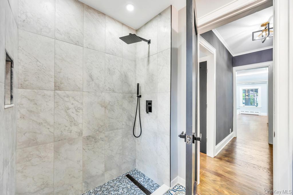 15 Superior Road Bellerose Village, NY 11001 - Photo 6 of 29 1 floor guest Bathroom with a walk in shower, wood finished floors, crown molding, and baseboard heating and Radiant heated floors