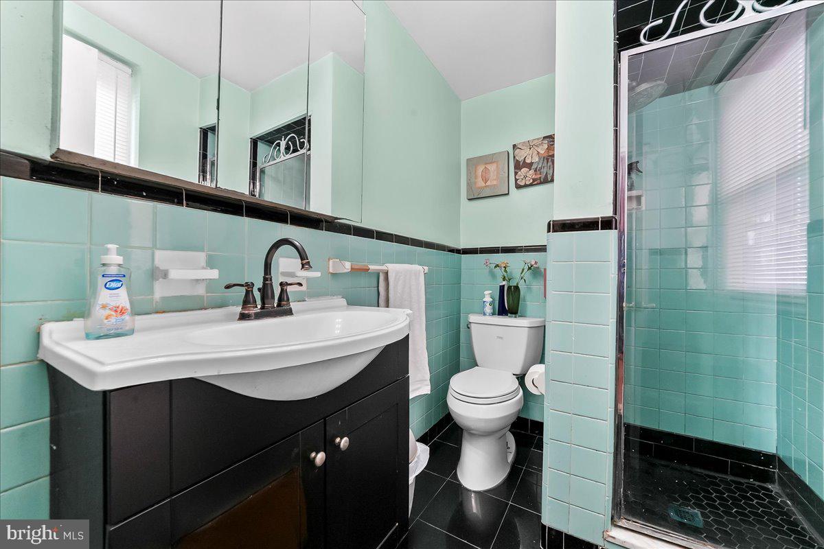 8309 Lynnewood Road Philadelphia, PA 19150 - Photo 15 of 28 a bathroom with a sink toilet and a mirror