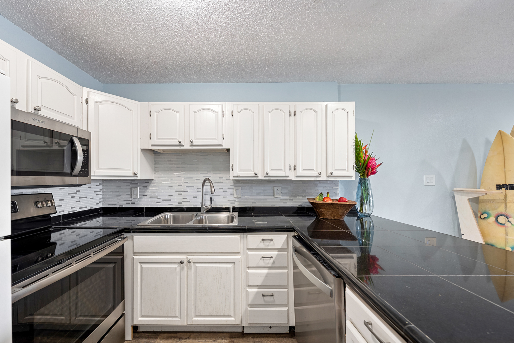 3411 Wilcox Road, Unit BV25 Lihue, HI 96766 - Photo 3 of 21 a kitchen with stainless steel appliances granite countertop a sink stove and microwave