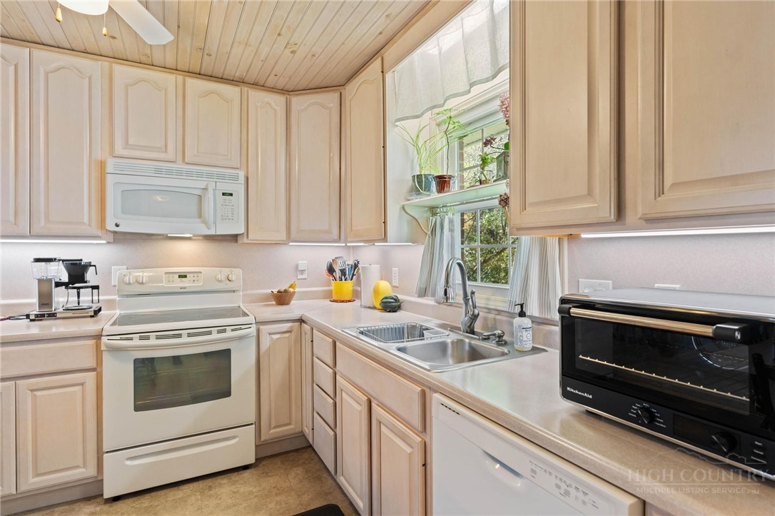 112 Chandy Street Boone, NC 28607 - Photo 16 of 50 a kitchen with granite countertop white cabinets and white appliances